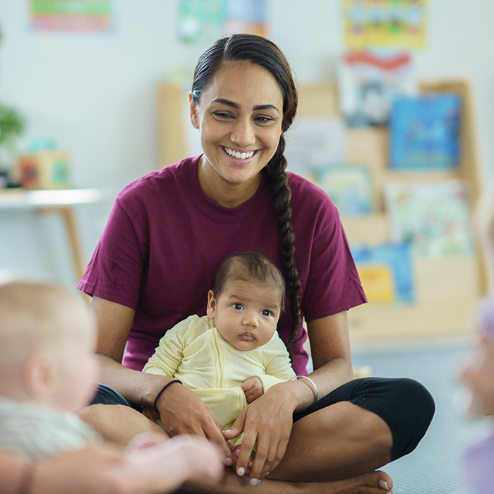 Image of a young mom holding a 3 month old baby in her lap
