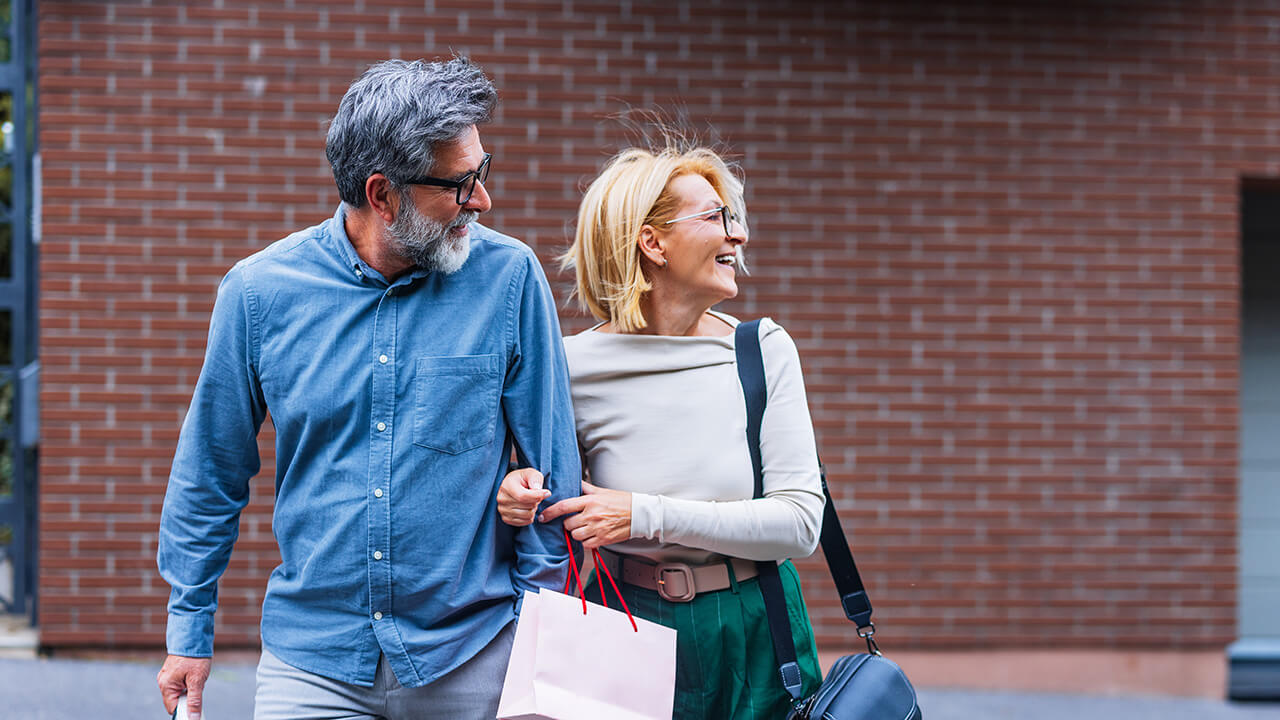 Middle aged male and female couple walking on a street