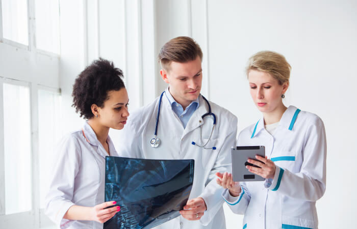 group of oncologists looking at charts and x-rays in hospital