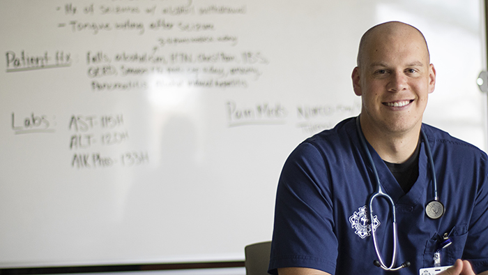Male nursing student in front of white board