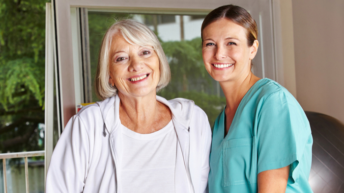 Senior woman standing with young female nurse