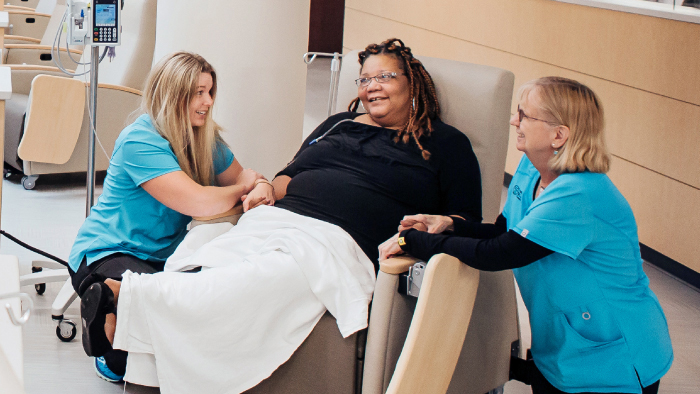 female nurses comforting female cancer patient