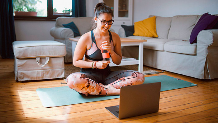 Young woman in workout gear on yoga mat