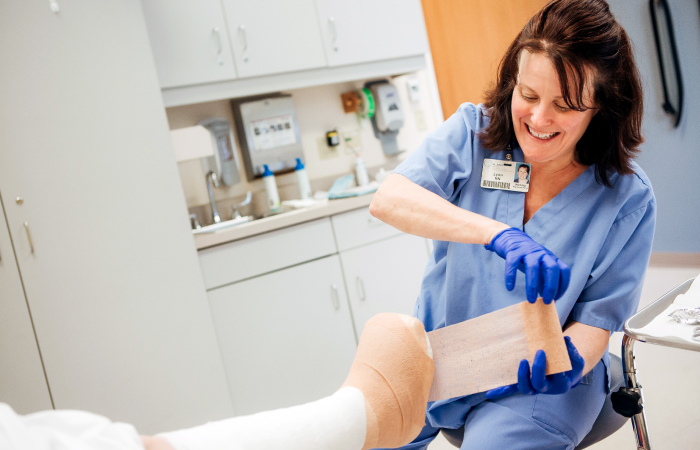 Female wound care specialist wraps a patient's foot