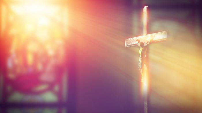 Radiant light through stained glass shining on crucifix