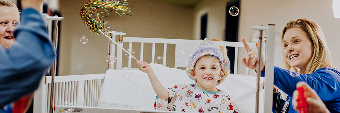 Young patient with nurse playing with bubbles