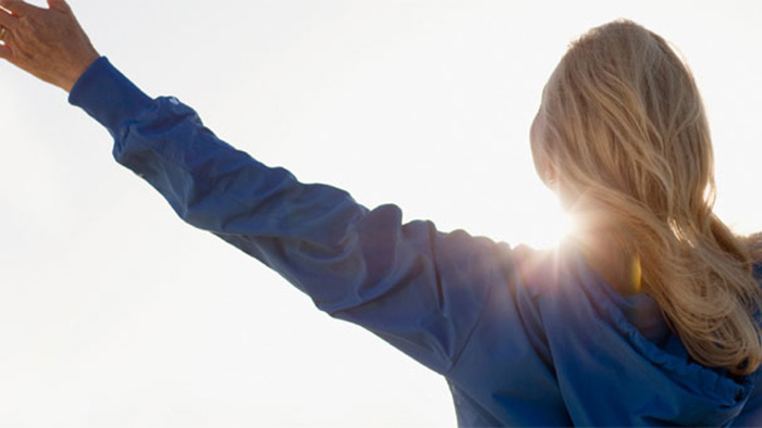 Health care worker stretching in the sun. 