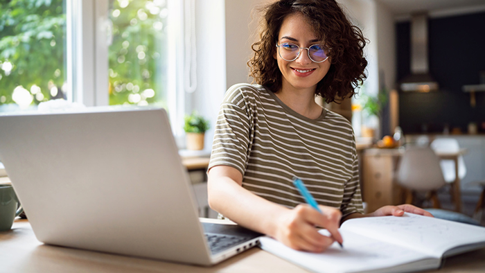 Young woman with laptop and notebook
