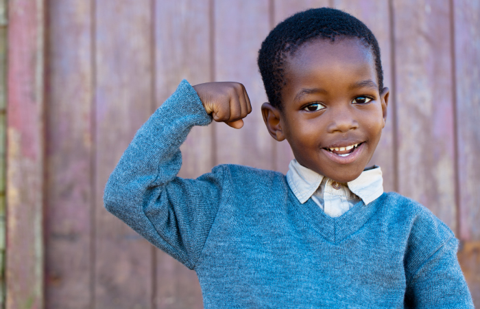 young boy showing stregnth