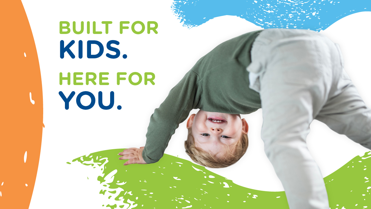 child dancing in front of a background painted with swirls