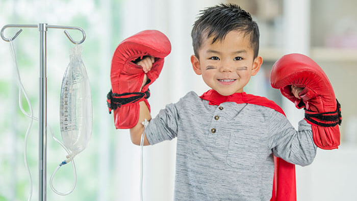 Young boy flexing his muscles with boxing gloves