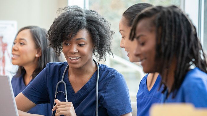Young nursing students using laptop in class