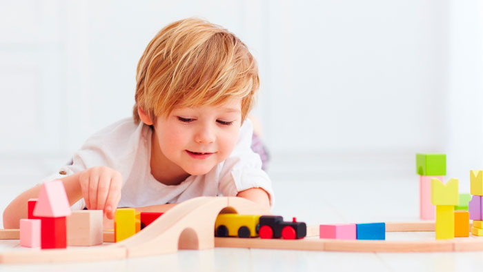 Young blonde boy playing with blocks
