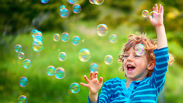 Young child playing with bubbles