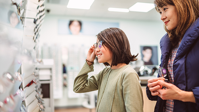 Young girl trying on a new pair of glasses