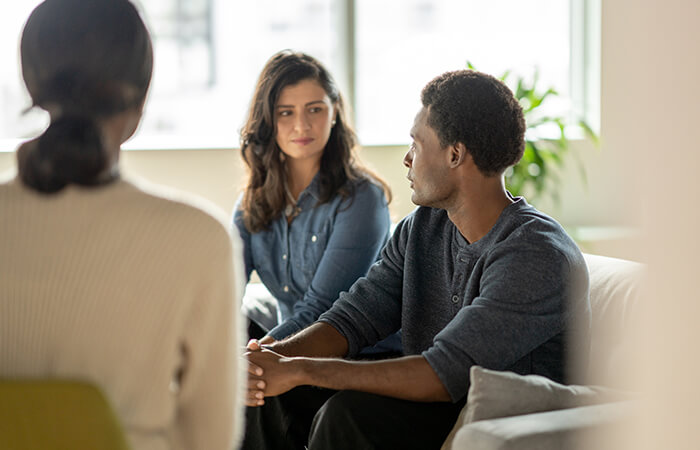 black man sharing in a support group circle with two other women 