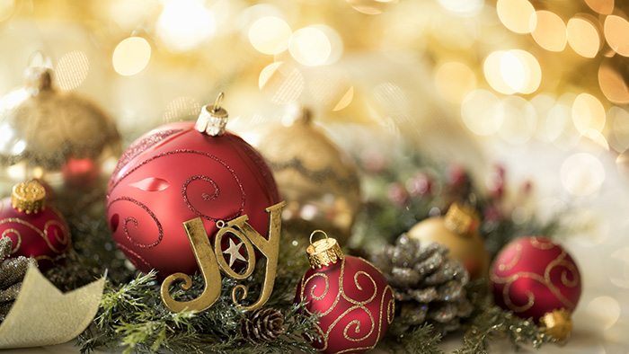 Christmas tree bulbs in greenery with golden light