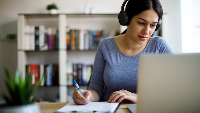 Young woman with headphones in front of a laptop computer