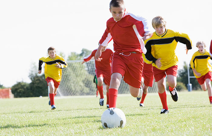 a childrens soccer team in red playing a game of soccer against a childrens soccer team in yellow