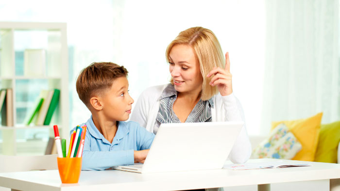 Young boy at laptop with tutor
