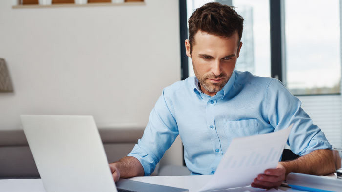 Man in blue shirt working at laptop computer