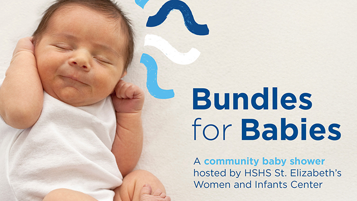 Infant in onesie curled up on blanket