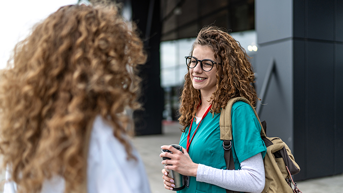 nurse talking with another nurse outside