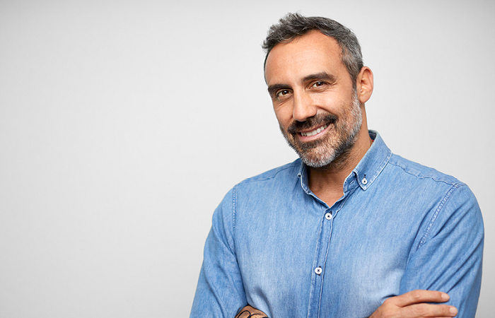 Middle aged male smiling with arms crossed