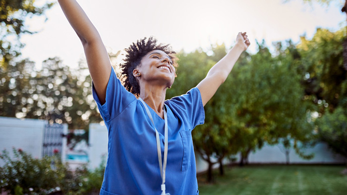 Health care colleague stretching and smiling outdoors