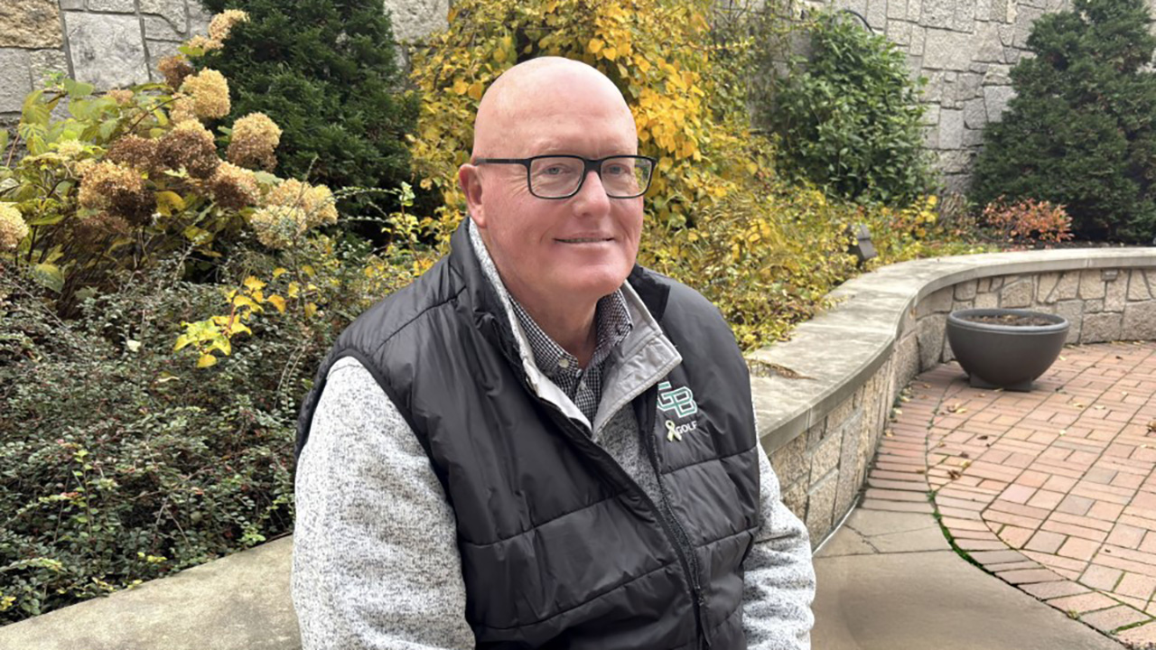 Patient Lee sitting in a garden area outside