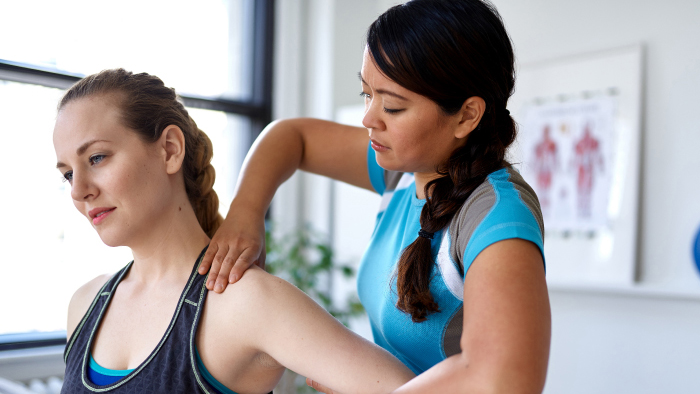 Physical therapist working on young athletic woman
