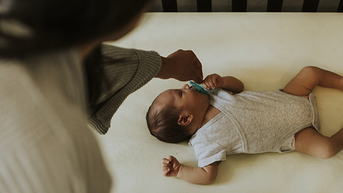 mother putting baby to sleep