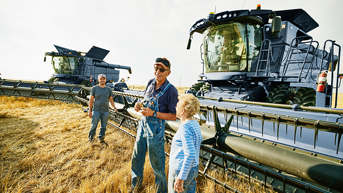 Active farm family in field next to combine