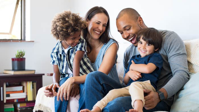 Young family of four laughing together