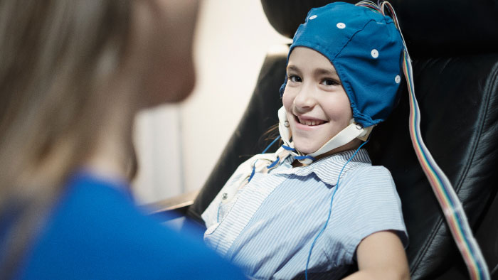 Young girl with blue cap for EEG study