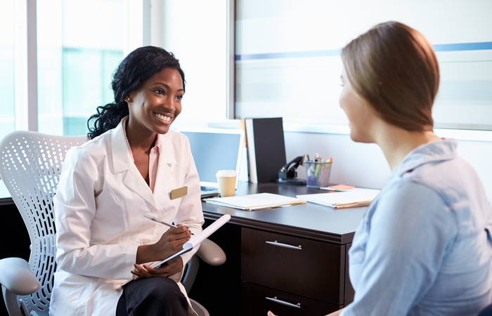 black female daughter talking to a female patient 