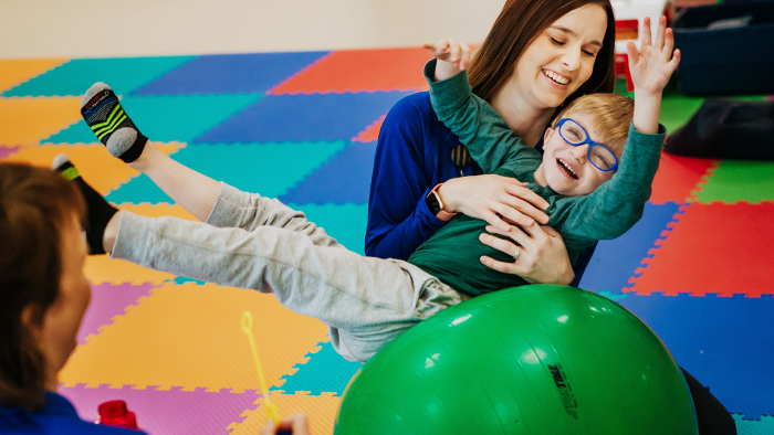 Young boy with glasses at play with a female nurse