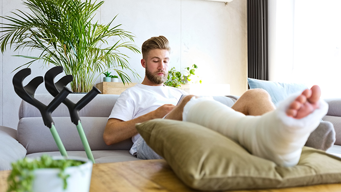 Man on couch with a broken leg