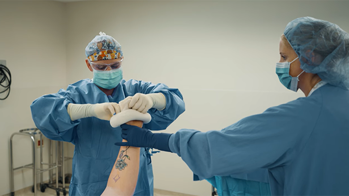 two surgical techs working on a patient
