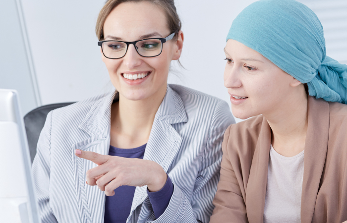 Female doctor and patient point to computer as they review test results