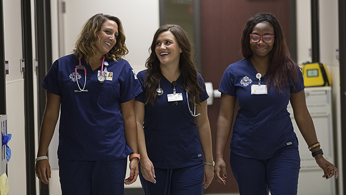 Three nursing students walking in hallway