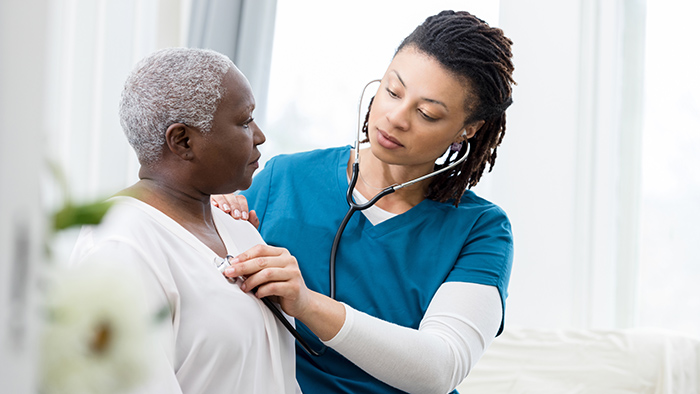 Medical Assistant listening to patient's heart