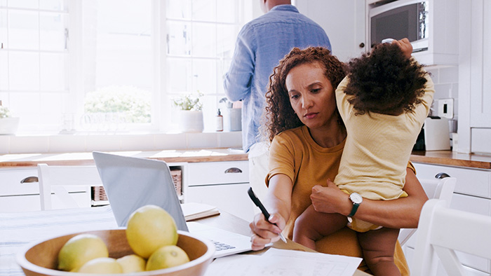 Family in kitchen reviewing benefits on computer.