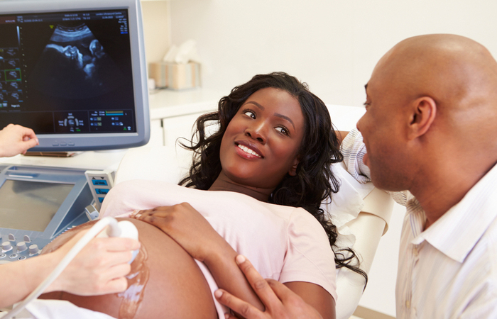 Young man and woman smile at each other during ultrasound