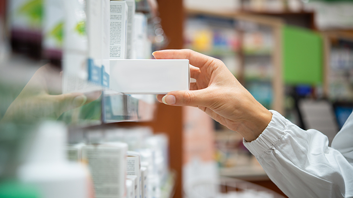 pharmacist grabbing medication from shelf