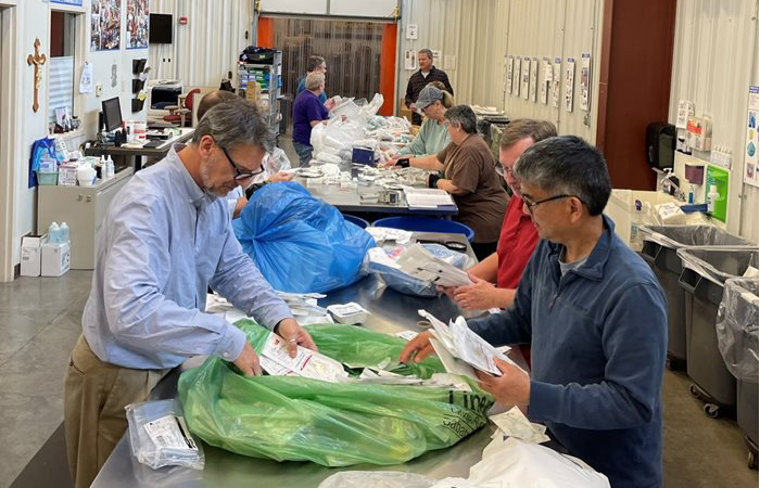 Volunteers sort through bags of donations to organize them and prep them for redistribution.