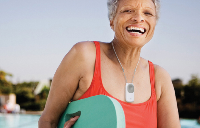 older black woman walking holding surfboard