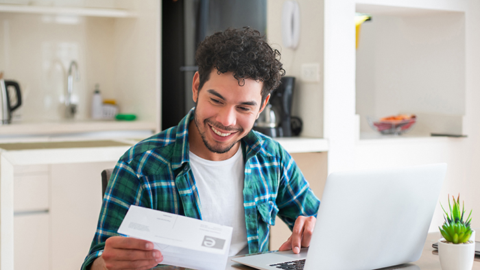Young man in front of computer paying tuition
