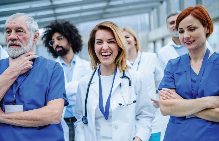 Providers stand together and a female doctor is laughing