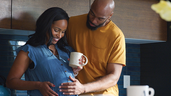 Young pregnant couple smiling at mom's belly